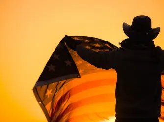 Texan in cowboy hat holding US flag